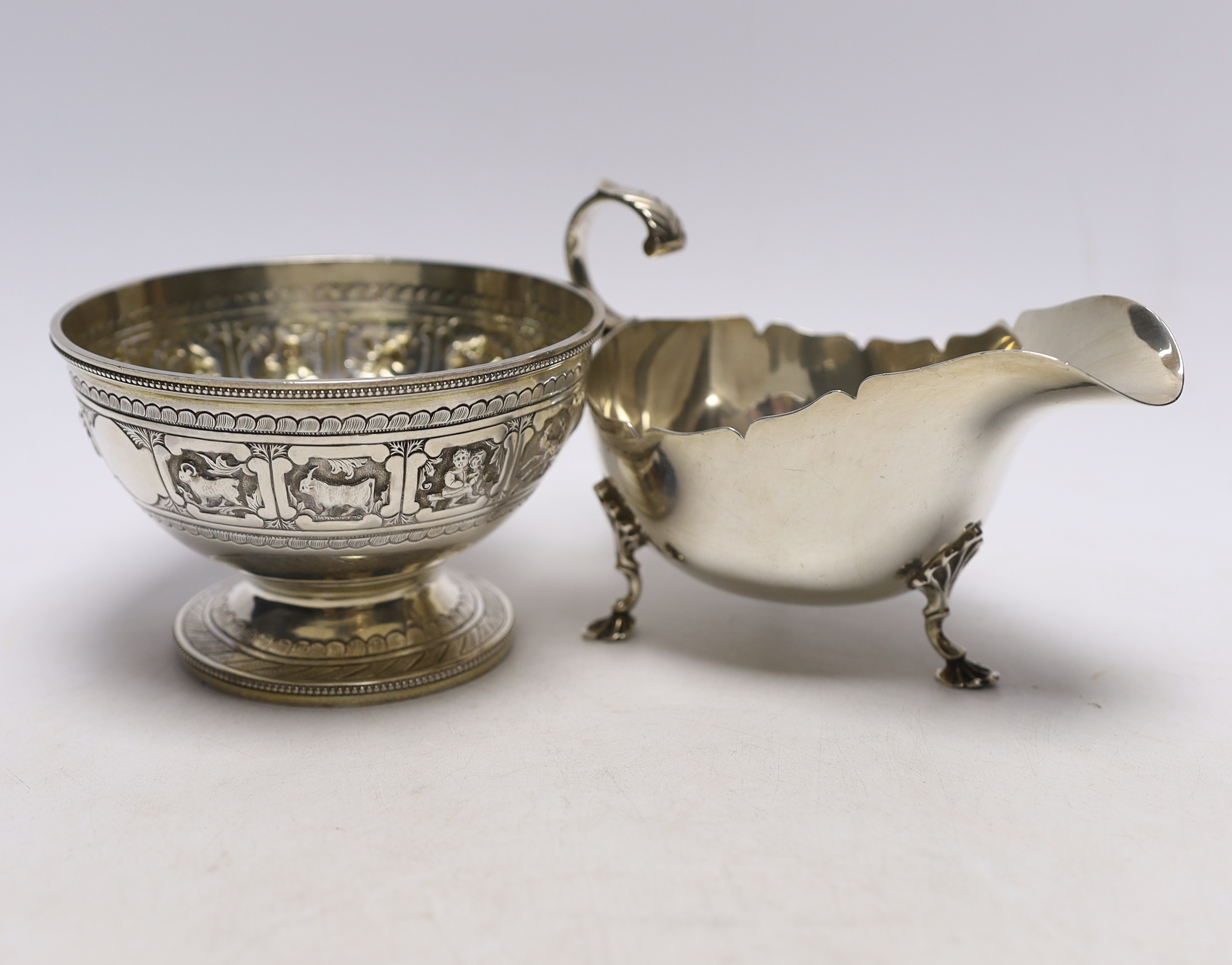 A Victorian silver 'Zodiac' pedestal bowl, by Frederick Elkington. London, 1881, diameter 12.4cm and a later silver sauceboat, 14.1oz.